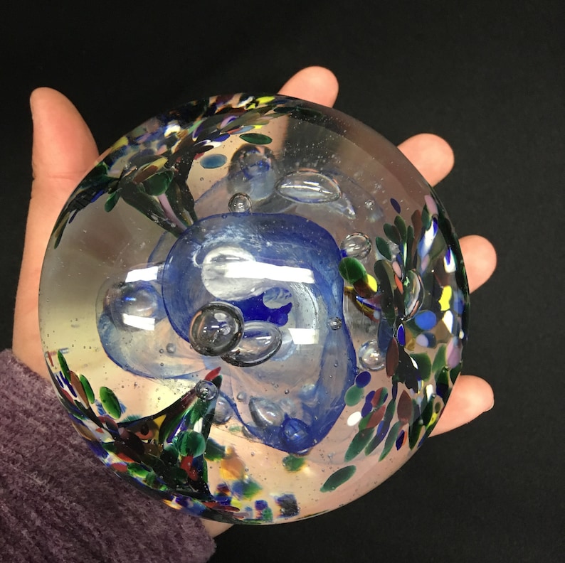 Blue and Red Mix BlueWhite center with Green Blown Glass Large Tri-Flower Paperweight on a Dark Wooden Light Box