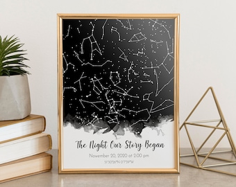 Puede incluir: Una impresión en blanco y negro con un marco dorado. La impresión presenta un mapa de constelaciones con el texto "The Night Our Story Began" y la fecha "November 20, 2020 at 2:00 pm" y las coordenadas "51°30′26″N 0'7'39"W".