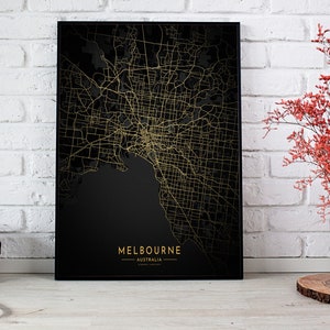 May include: A black and gold map print of Melbourne, Australia. The map shows the city's streets and waterways in gold against a black background. The city name and country are printed in gold at the bottom of the print.