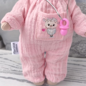 May include: Handmade doll in pink jumpsuit with pocket and sticker on it. There is a tag ,, Cutedollshandmade,,on the romper. The doll has a silver necklace with a mini pacifier. The doll is approximately 20 cm tall.