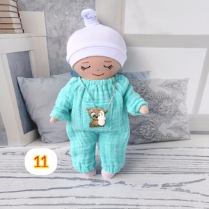 11. May include: A handmade doll wearing a light blue pajama set and a white cap.