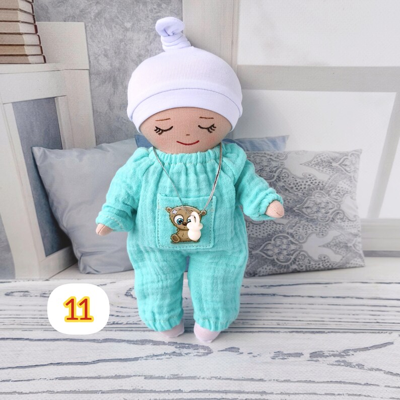 11. May include: A handmade doll wearing a light blue pajama set and a white cap.