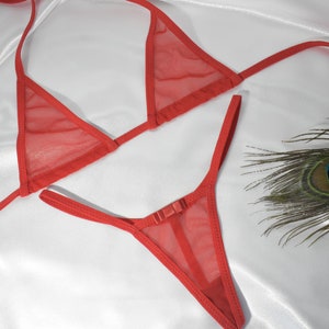 May include: Red mesh lingerie set with a triangle bra and a thong. The set is made of a sheer, delicate fabric.