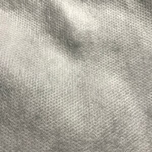 Puede incluir: Primer plano de una tela blanca texturizada con un patr&oacute;n sutil de peque&ntilde;os puntos.