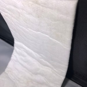 Puede incluir: Una pieza rectangular de material de aislamiento blanco y texturizado.