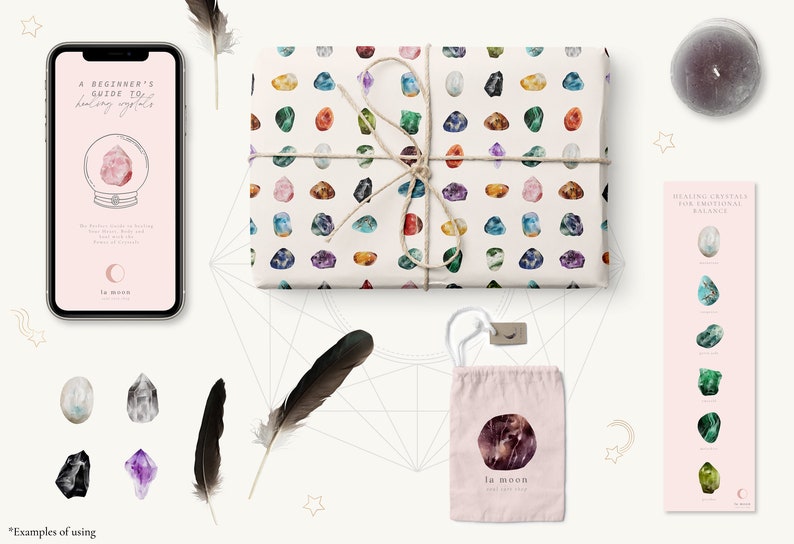 May include: A flat lay image of a pink and white gift bag with a crystal pattern, a pink and white card with the text "Healing Crystals for Emotional Balance", a pink and white phone case with the text "A Beginner's Guide to Healing Crystals", a pink and white pouch with the text "la moon", and a black feather.