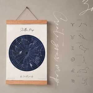 May include: A wooden-framed star map print with a dark blue celestial design. The print includes constellations, zodiac symbols, and the text "Stellar Map". The words "Create your map" are written on the right side. The text "Great idea to create stellar map for your family or friends" is also visible.