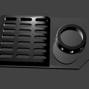 May include: Black plastic part with a rectangular grid pattern and a round hole with a smaller ring inside.