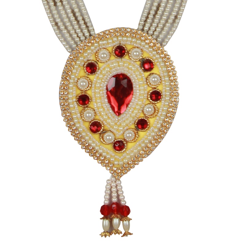 Op de afbeelding: Een gouden en witte kralenketting met een grote ovale hanger. De hanger is versierd met rode en witte kralen en een grote rode edelsteen.