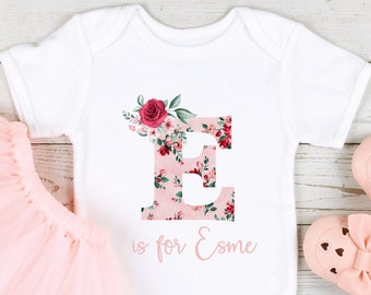 Rose rose lettre florale initiale et nom tenue pour bébé fille (Babygrow Sleepsuit Vest Body | Nouveau cadeau pour bébé fille | Option coton biologique)