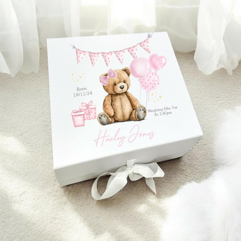 May include: White keepsake box with a watercolor illustration of a teddy bear, balloons, and gifts. The box has a pink bow and the name "Harley Jones" in pink script. Text includes birth details and weight.