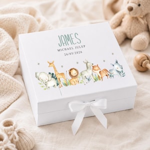 May include: A white gift box decorated with a watercolour illustration of safari animals. The box is tied with a white ribbon and features the name "JAMES" and the date "26/05/2026" in green text. Animals include an elephant, giraffe, lion, zebra, and rhino.