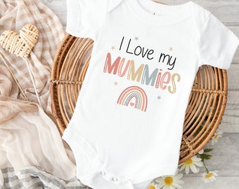 May include: White baby onesie with short sleeves featuring a rainbow and the text "I Love my Mummies".