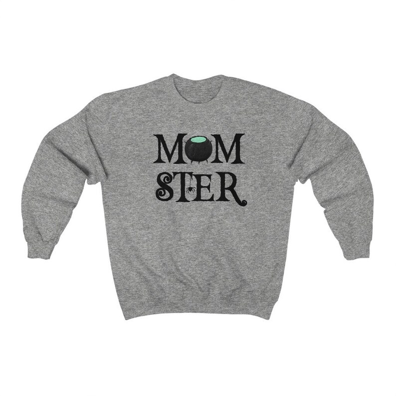May include: Gray sweatshirt with the text "MOMSTER" in black. The "O" in "MOM" is replaced with a black cauldron with green liquid inside. A small black spider hangs from the cauldron.