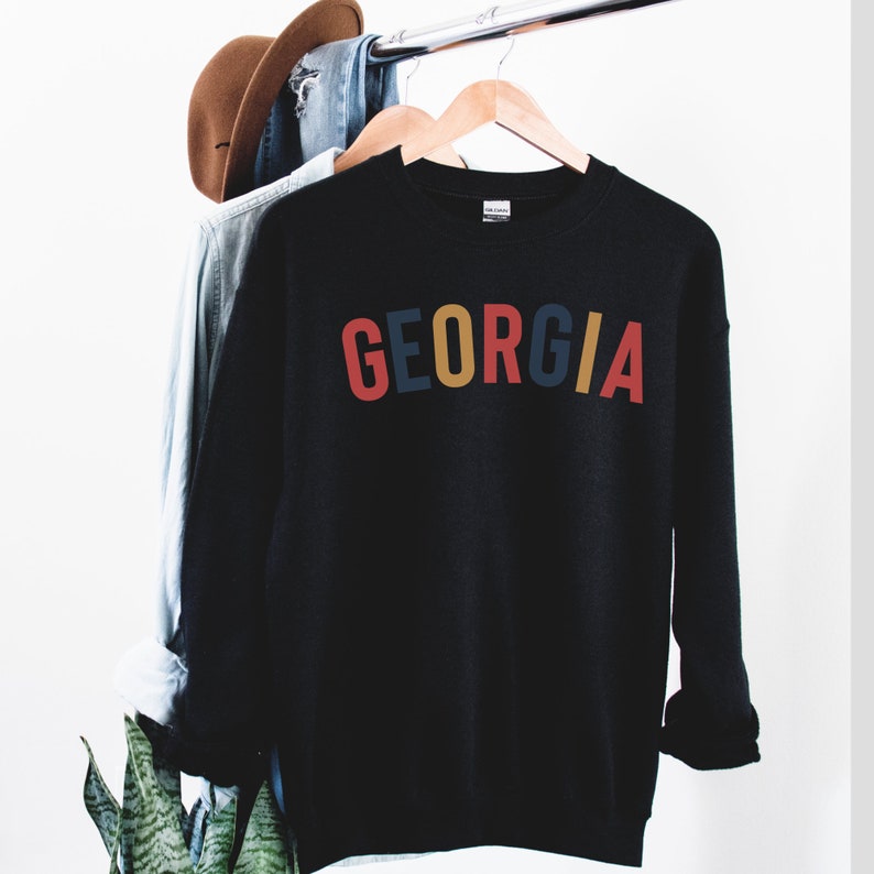 May include: Black sweatshirt with the word "GEORGIA" printed in red, blue, yellow, and orange letters.