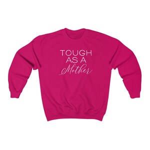 May include: A pink sweatshirt with the text "TOUGH AS A MOTHER" in white lettering.