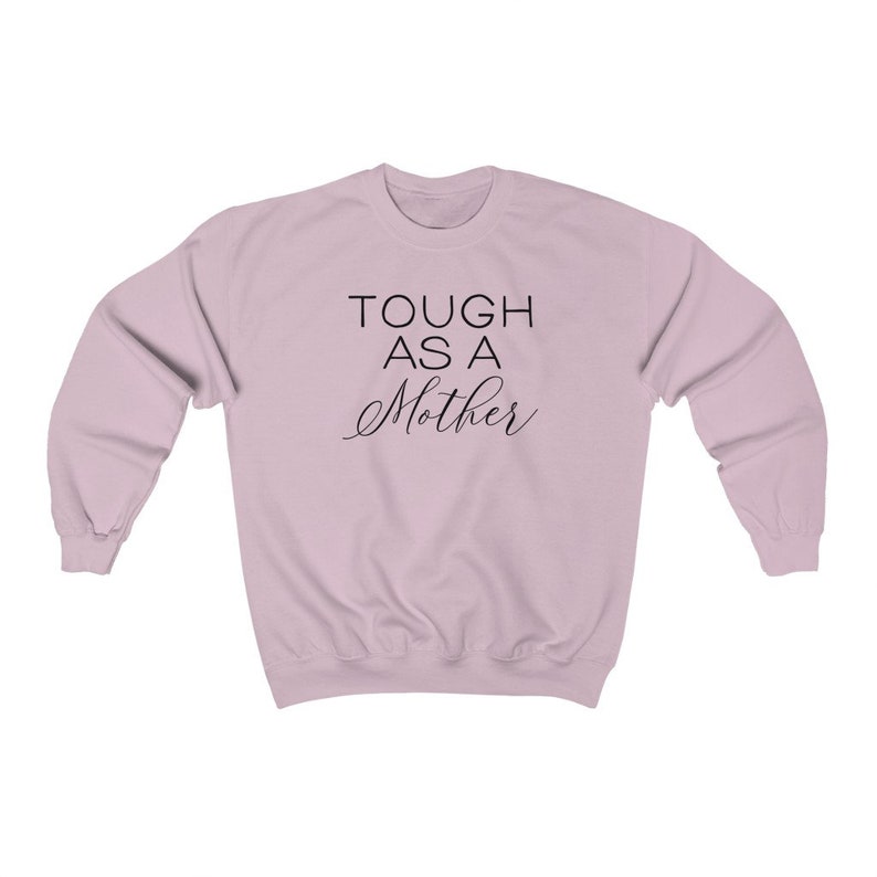 May include: A light pink sweatshirt with the text "TOUGH AS A MOTHER" printed in black.
