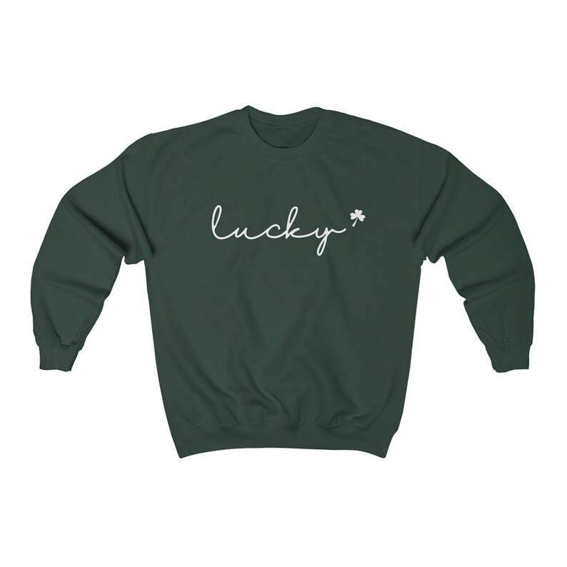 以下が含まれることがあります： 暗い緑色のスウェットシャツに、白い筆記体で「lucky」という文字と、小さな白いクローバーが書かれています。