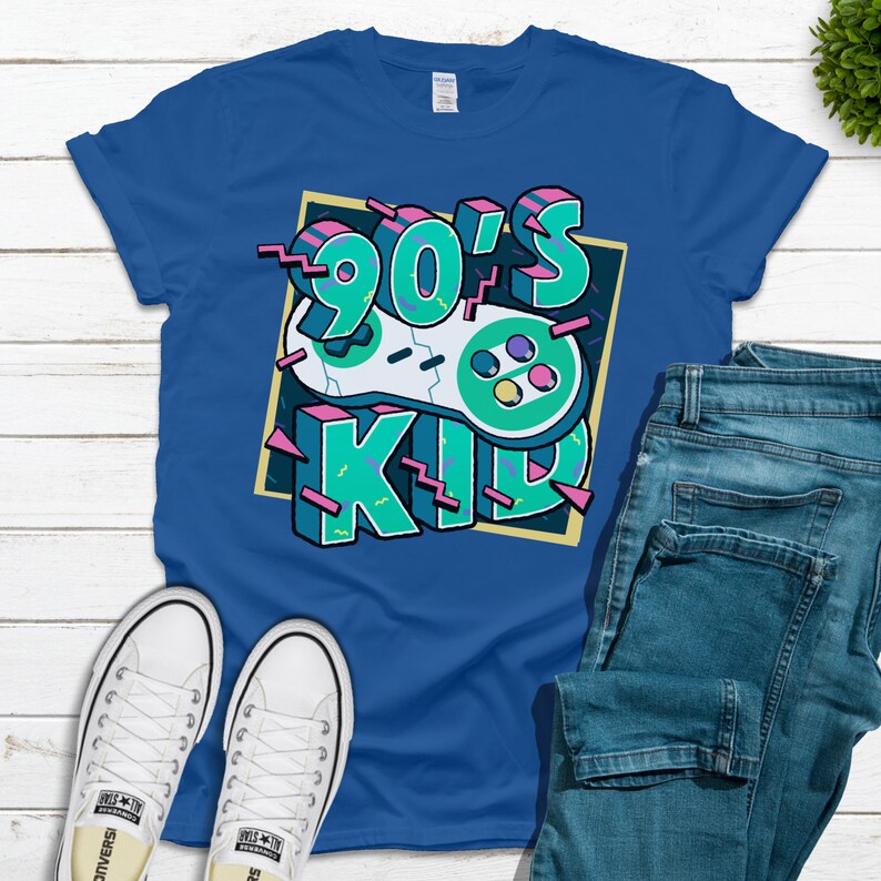 May include: A royal blue t-shirt with a graphic design of a retro video game controller and the text "90's Kid" in a colorful, pixelated font.