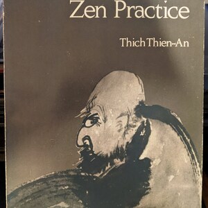 May include: A book cover with a dark gray background and the title "Zen Philosophy, Zen Practice" in white text. The author's name, "Thich Thien-An", is printed below the title in white text. A black and white illustration of a person's face is in the lower right corner of the cover.