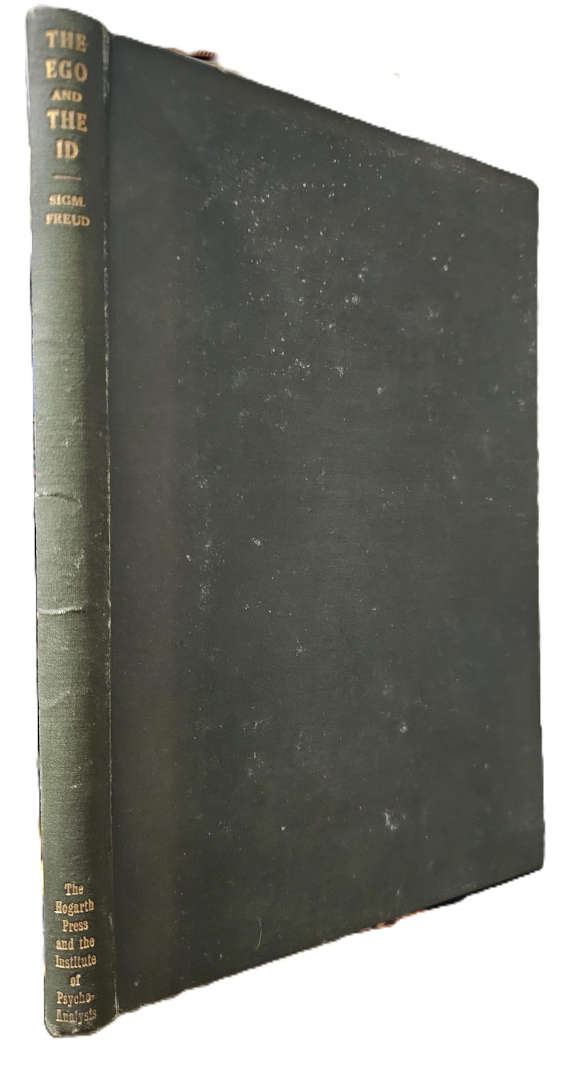 Op de afbeelding: Een donkergroen hardcover boek met de titel "The Ego and the Id" van Sigmund Freud. De rug van het boek toont de titel en de naam van de auteur in gouden letters. De naam van de uitgever, "The Hogarth Press and the Institute of Psycho-Analysis", is ook zichtbaar.