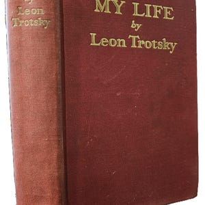 May include: A red hardcover book with the title "MY LIFE" by Leon Trotsky printed in gold lettering on the front cover.