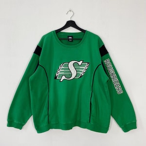 May include: Green sweatshirt with the word "ROUGHRIDERS" printed on the right sleeve. The front features a large white and green logo with the letter "S". Black accents are on the sleeves and sides.