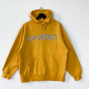 May include: Mustard yellow hoodie with a drawstring hood and a front pocket. The text "DeVry University" is printed across the chest in black and white. The sweatshirt is made of a soft material.