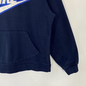 May include: Navy blue hoodie with a white and blue logo on the upper left chest. The hoodie has a kangaroo pocket and a drawstring hood. The fabric appears to be a soft, medium-weight material, suitable for casual wear.