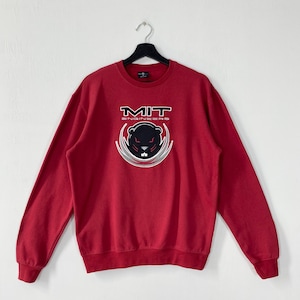 Könnte beinhalten: Rotes Sweatshirt mit dem Text "MIT ENGINEERS" und einer Grafik eines schwarzen Bibers mit weißem und silbernem Umriss. Das Sweatshirt hat lange Ärmel und einen Rundhalsausschnitt.