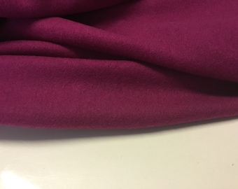 May include: Close-up of a deep magenta fabric with a soft, fuzzy texture. The fabric is folded and draped, showing its drape and texture.