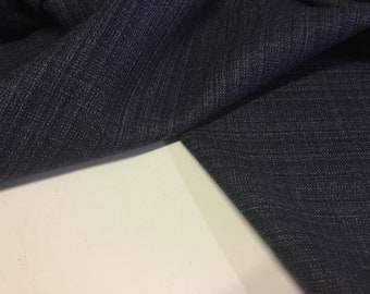 Puede incluir: Primer plano de una tela azul oscuro con tejido texturizado. La tela tiene un brillo sutil y una sensación ligeramente áspera.