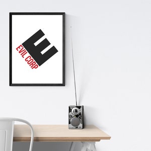 May include: A framed print with the text "EVIL CORP" in red and a black "E" shape. A small, silver radio with an antenna sits on a wooden table. The print is in a black frame.