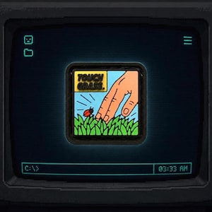 May include: A square patch featuring a cartoon hand reaching towards green grass with a small red ladybug. The text "TOUCH GRASS." is printed in black on a yellow background. The patch is displayed on a dark screen with a command line interface.