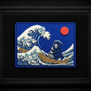 May include: A rectangular morale patch featuring a graphic of a skeleton in a hooded robe rowing a wooden boat through a large, stylized white and blue wave. A solid red circle representing the sun is positioned in the upper right corner.
