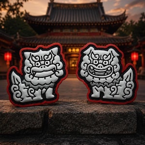 May include: Two silver-colored lion dog figures with detailed manes and tails, featuring bold black outlines and a vibrant red border. These stylized guardian lion ornaments are crafted with a raised, embossed texture and a distinct, symmetrical design.