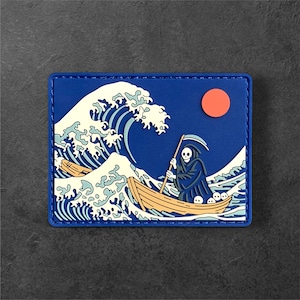 May include: A rectangular patch with a blue border features a Grim Reaper in a boat, navigating a large wave. The design includes a rising sun and stylized waves in white and blue, reminiscent of Japanese art.