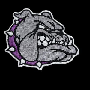 May include: Embroidered patch of a gray bulldog with a purple spiked collar. The bulldog has a fierce expression with bared teeth.