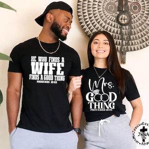 May include: Two people wearing matching black t-shirts. One shirt reads "HE WHO FINDS A WIFE FINDS A GOOD THING PROVERBS 18:22" in white text. The other shirt says "Mrs. GOOD THING PROVERBS 18:22" in white script.