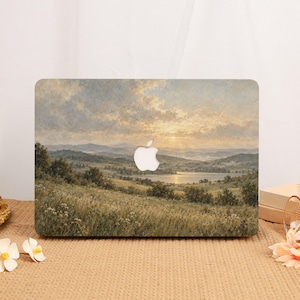 Può includere: Una skin per laptop con un dipinto paesaggistico di un prato con fiori selvatici, colline in lontananza e un lago sotto un cielo nuvoloso al tramonto. Il design include un ritaglio centrale per il logo Apple.