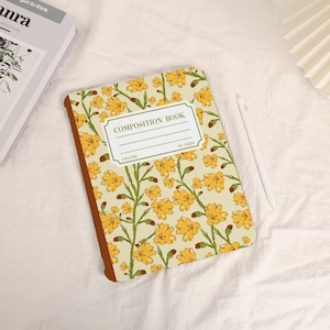 Puede incluir: Un cuaderno de composición amarillo con un patrón floral. La portada tiene una etiqueta que dice "Composition Book" con espacios para "College" y "100 Pages".