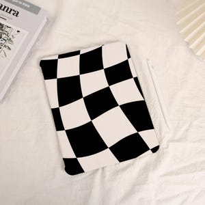 May include: A black and white chequered iPad case with a wavy pattern. The case is made of a soft, durable material and is designed to protect your iPad from scratches and bumps.