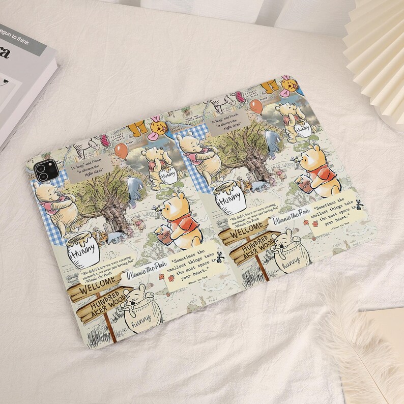 May include: A tablet case featuring a repeating pattern of Winnie the Pooh illustrations, honey pots, and quotes. The case has a light beige background with a map-like design and blue gingham accents. The case is designed to fit a tablet.