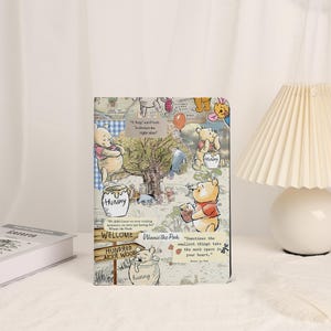 May include: A rectangular Winnie the Pooh-themed notebook featuring illustrations of the beloved bear and friends. The cover includes text and quotes from the stories, with a collage-like design in various colors.