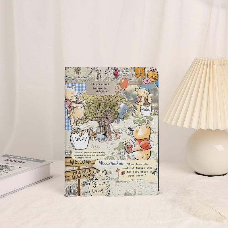 May include: A rectangular Winnie the Pooh-themed notebook featuring illustrations of the beloved bear and friends. The cover includes text and quotes from the stories, with a collage-like design in various colors.