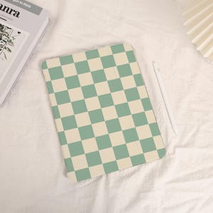 May include: A green and cream chequered iPad case. The case is made of a soft, durable material and has a sleek, modern design.