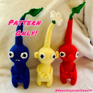 May include: Three crocheted plushies in the shape of the characters from the video game Mother 3. The plushies are blue, yellow, and red. The text "PATTERN ONLY!" is written in pink letters on the image.