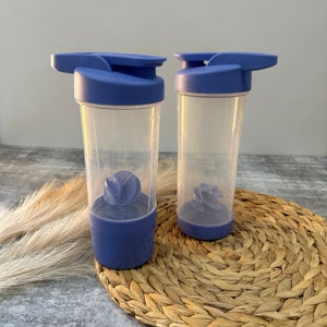 May include: Two blue plastic shaker bottles with clear containers and a blue mixing ball inside. The bottles have a flip top lid and a carrying handle.