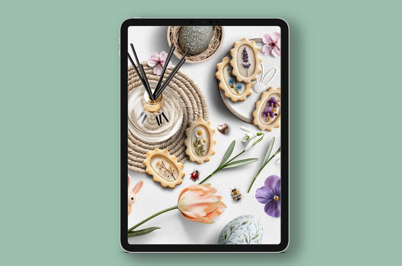 May include: A white background with a variety of spring-themed decorations, including a floral-patterned Easter egg, a nest with a speckled egg, a bouquet of white snowdrops, a pink tulip, a small bee, a glass bottle with black diffuser sticks, a brown woven mat, and several cookies decorated with pressed flowers.