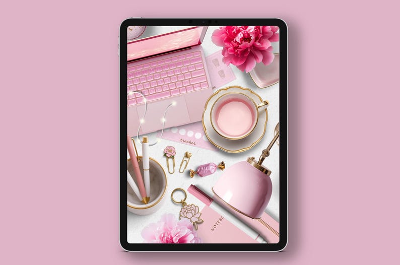 May include: A flat lay of a pink laptop, a pink teacup and saucer, a pink lamp, a pink notebook, and other pink office supplies on a white surface.